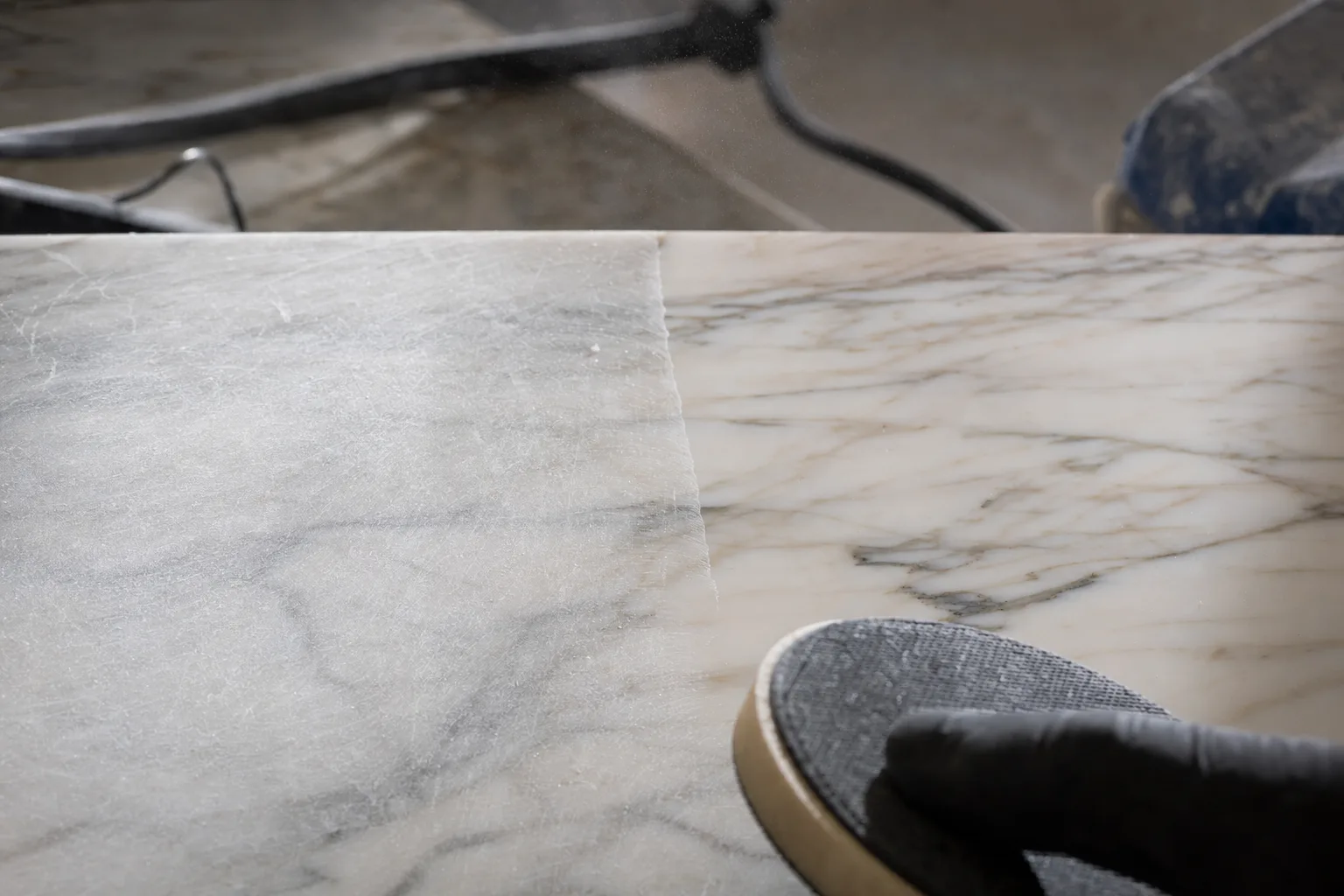 Close-up of etch and scratch damage being worked out of a marble surface
